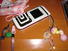 a cell phone sitting on top of a wooden table next to other toys and accessories