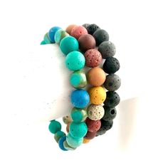 NUMBER 1 & 3 ARE RESERVED.... PLEASE DO NOT BUY.... THANK YOU  Very cute & colorful dyed lava rock bracelets! Three different kinds, one of each style available:  1. Black & Gray-RESERVED  2. Aqua Green & Blue 3. Brown Pink Yellow Mix-RESERVED  Each bracelet is beaded on clear strong elastic, and measures about 7 inches inside. These can be worn with any style outfit or add to your favorite stacking bracelets! Rock Bracelets, Bullet Earrings, Lava Rock Bracelet, Semiprecious Stone Jewelry, Stacking Bracelets, Hippie Bracelets, Rainbow Beads, Lava Rock, Dundee