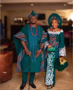 two people standing next to each other wearing green outfits