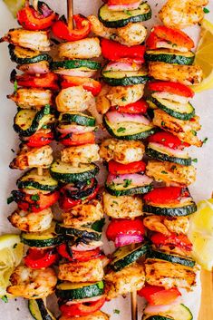 grilled chicken and vegetable kabobs with lemon wedges