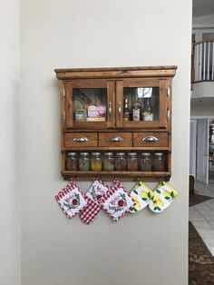 a wall mounted spice rack with jars and napkins