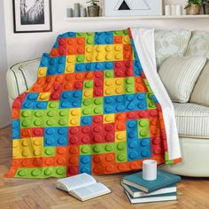 a blanket that is made out of legos on the floor next to a couch