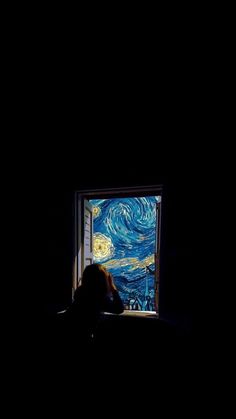 a person laying in bed looking at the starry night painting