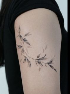 a woman's arm with a branch tattoo on the left side of her body