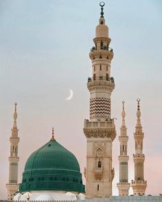 a large white building with a green dome and two smaller buildings in the back ground