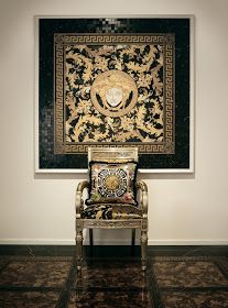 a chair sitting in front of a painting on the wall