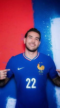 a man posing for a photo in front of a red and blue wall