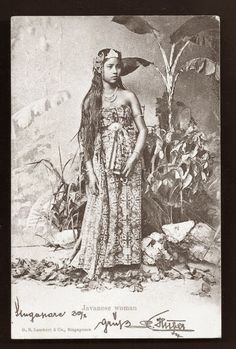 an old photo of a woman with long hair wearing a dress and headdress