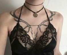 a woman wearing a black bra and choker with an animal head on it's chest