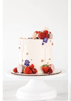 a white cake topped with strawberries and flowers