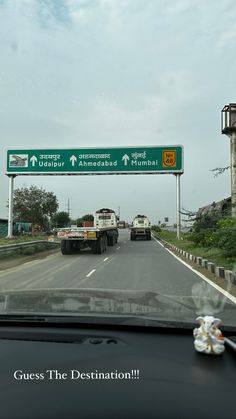 two trucks driving down the road under an overpass with street signs above them that read, guess the destination?