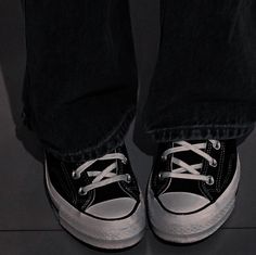 a person wearing black and white shoes standing up