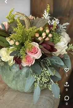 a vase filled with lots of flowers on top of a table