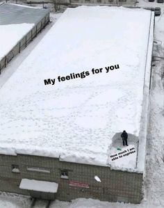 an aerial view of a building with snow on the ground and two men standing in front of it