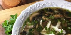 a white bowl filled with soup on top of a wooden table