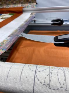 a pair of scissors sitting on top of a piece of fabric next to a sewing machine