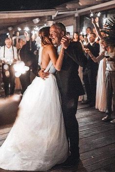 a bride and groom share their first dance with sparklers