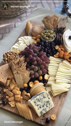 an assortment of cheeses and nuts on a cutting board