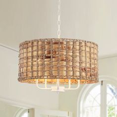 a chandelier hanging from the ceiling in a living room with white walls and windows