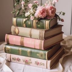 three books stacked on top of each other with flowers in the middle one is green and pink