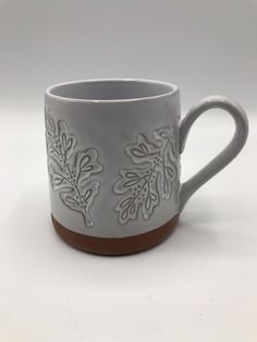 a white and brown coffee cup sitting on top of a table