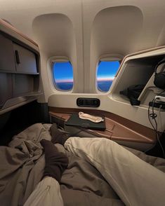 an airplane bed with two windows and a laptop on it