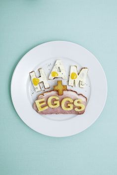 a plate that has eggs on it with the words ham and eggs written in letters