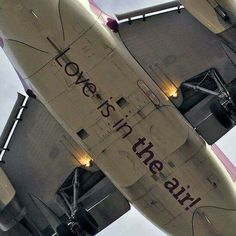 an airplane with the words love is in the air written on it's side