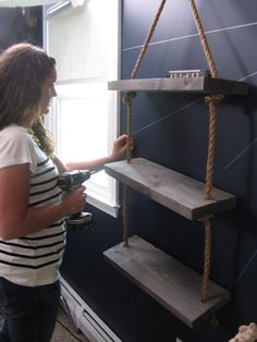 a woman is working on some shelves in a room