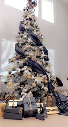 a white christmas tree with black and gold decorations