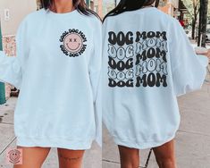 two women wearing sweatshirts with dogs on them, one saying give me a double shot and the other saying my dogs are on