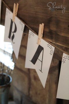 some clothes pins are hanging on the clothes line with letters and numbers attached to them