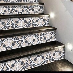 the stairs are decorated with black and white tile designs, along with wooden handrails