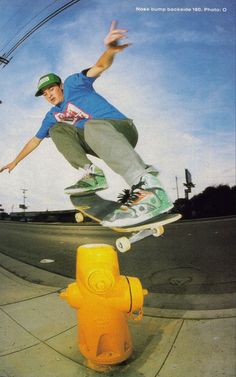 a man riding a skateboard over a yellow fire hydrant