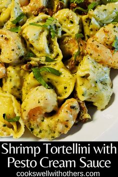 shrimp tortellini with pesto cream sauce on a white plate