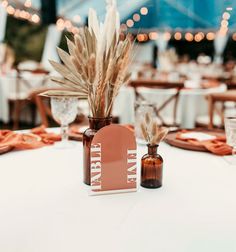 there is a vase with some plants in it on top of a white table cloth