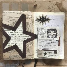 an open book with drawings and writing on it, including a star in the middle