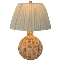 a wicker lamp with a white shade on it