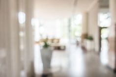 blurry photo of an open house door and the hallway leading to another room with white walls