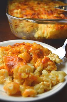 a white plate topped with macaroni and cheese next to a casserole dish