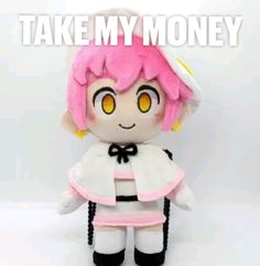 a small doll with pink hair and yellow eyes sitting in front of a white background