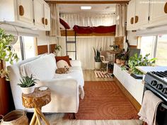 the interior of a small camper with white furniture