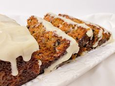 two slices of carrot cake with icing on a white plate