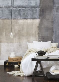 a bed with white linens and pillows in front of a wall that has been painted gray