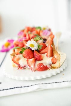 a piece of cake with strawberries and flowers on it