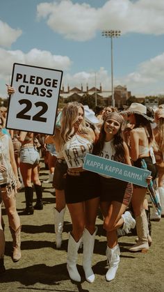 two women in cowboy outfits hold up a sign that reads please class 22 happy kapa gahmaa