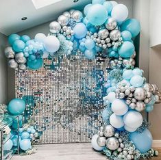 a blue and silver balloon arch with balloons