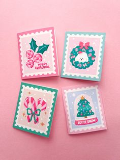 four christmas cards on a pink background