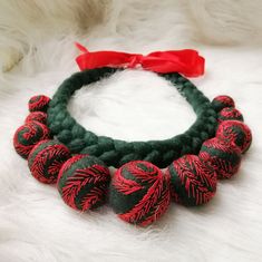 a close up of a bracelet on a white furnishing with red and black beads