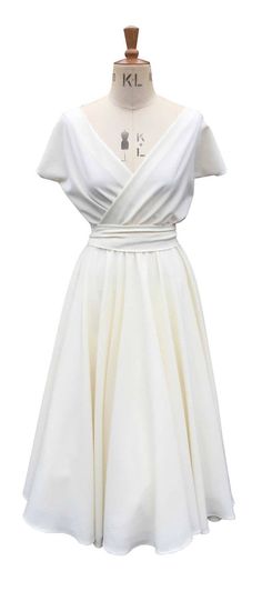 This listing is for a gorgeous Short Sleeve Wrap Dress with a full circle skirt in Ivory It has a lovely wrap front which flatters any bust size, a very flattering full circle skirt and a cute matching belt. This dress is a pull on style with an elasticated waist and is unlined. WRAP DRESS BUST WAIST HIP SIZE 8 32 24 35 SIZE 10 34 26 37 SIZE 12 36 28 39 SIZE 14 38 30 41 SIZE 16 40.5 32.5 43.5 SIZE 18 43 35 46 SIZE 20 45.5 37.5 48.5 LENGTH 48 INCHES Please note the dress is shown with a petticoat White V-neck Dress With Pleated Waist, White Surplice Neckline Evening Dresses, White V-neck Wrap Dress For Formal Occasions, Cream V-neck Lined Dresses, White V-neck Evening Wrap Dress, White V-neck Wrap Dress For Evening, Elegant Beige Wrap Dress With Surplice Neckline, White Wrap Dress For Spring Wedding, White Fitted Wrap Dress For Evening